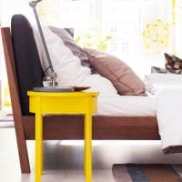 Желтый стул перед кроватью в спальне
