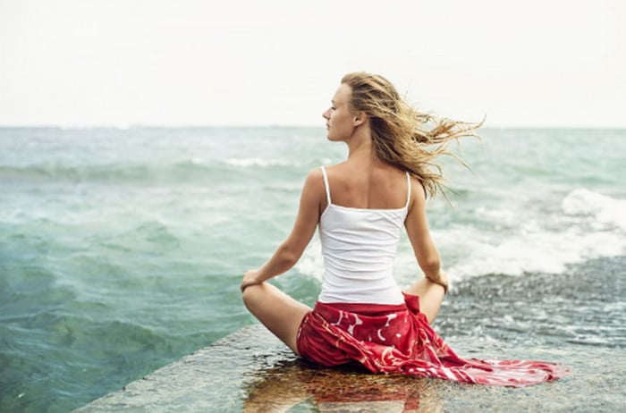 девушка медитирует на берегу моря